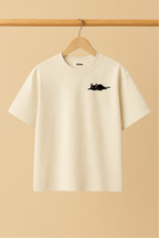 Ziaa's white t-shirt with a small black cat graphic and text says"Born to nap, forced to work"