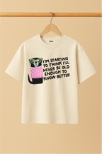 Ziaa's white t-shirt with a dog graphic and text of "I'm starting to think I'll never be old enough to know better