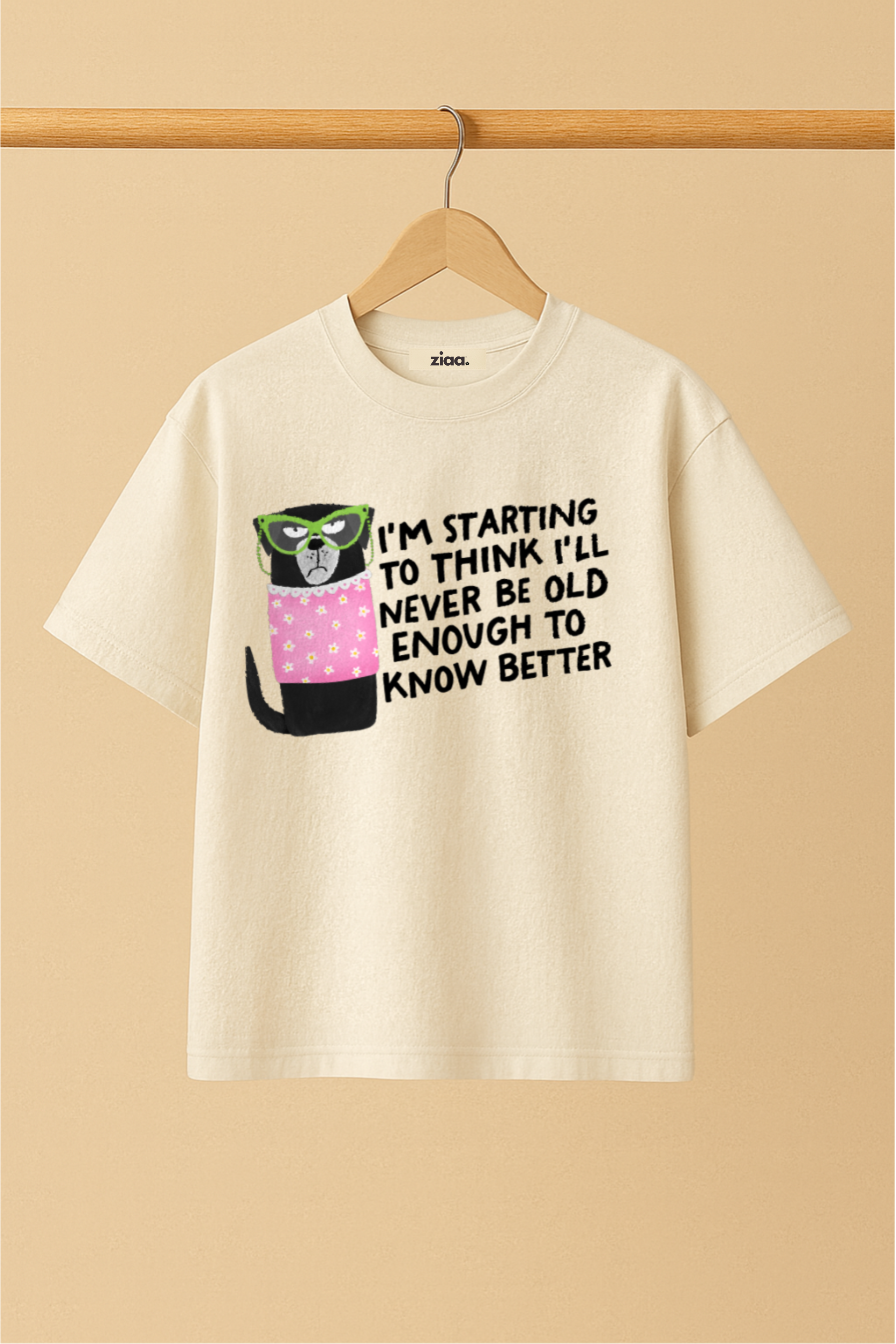 Ziaa's white t-shirt with a dog graphic and text of "I'm starting to think I'll never be old enough to know better