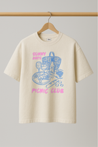 ZIAA "Sunny Days Picnic Club" graphic t-shirt with illustration of picnic items, white color base with pink and blue graphic